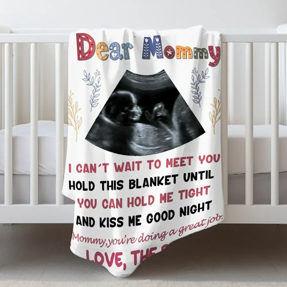 Custom sonogram picture blanket draped over a white baby crib