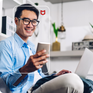Image of man using McAfee on his mobile device and laptop