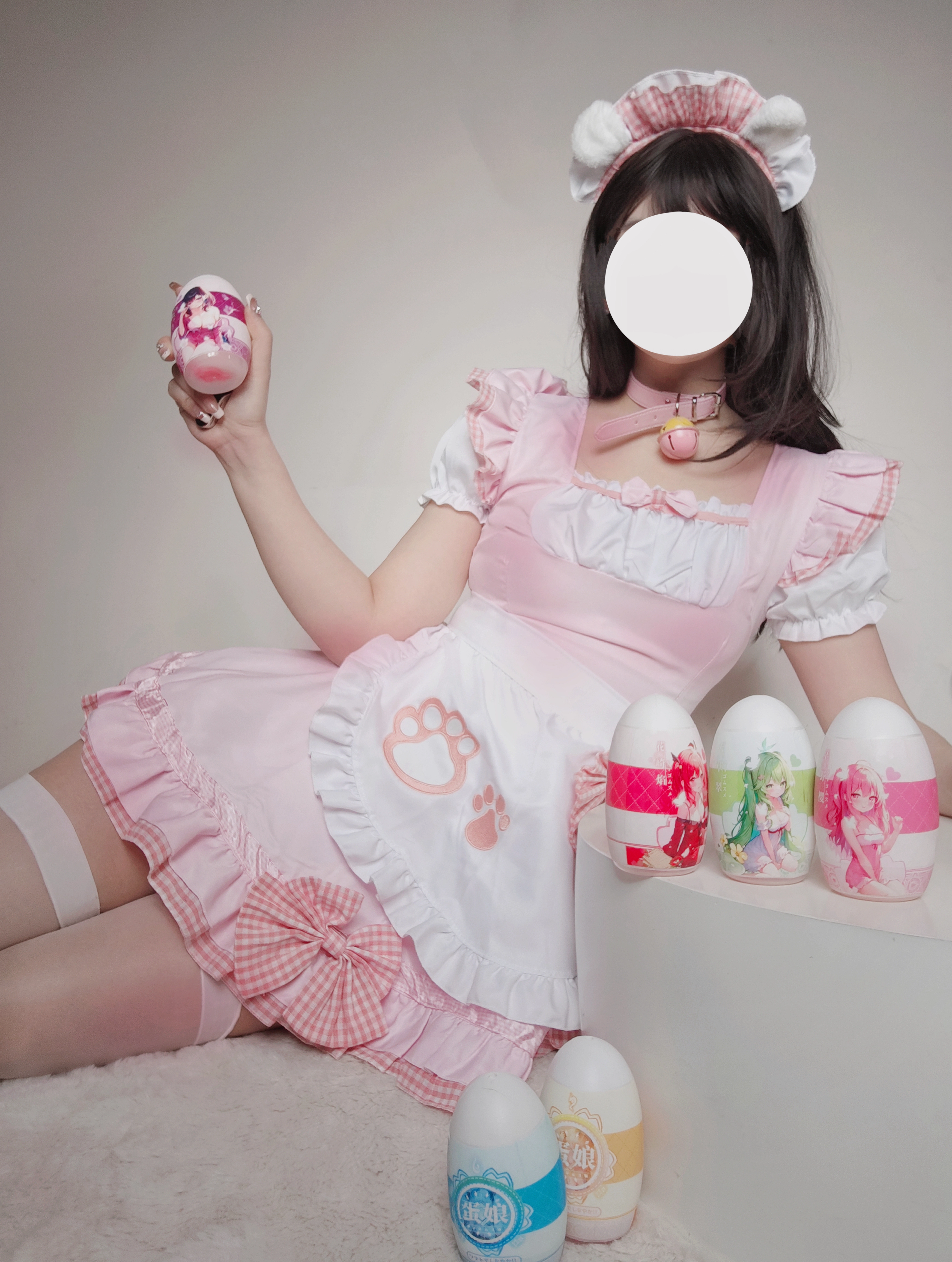 Anime-inspired manual onahole with product care accessories on a clean neutral surfa