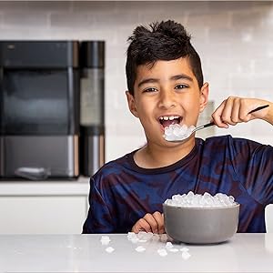 Petit garçon mangeant des pépites de glace